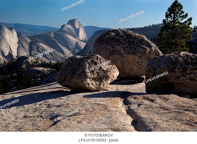 View of Half Dome in late afternoon summer sunlight, across granite trail, Olmsted Point, Yosemite
