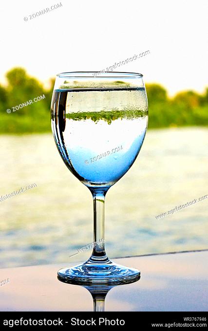 Glass of water on the table with reflection