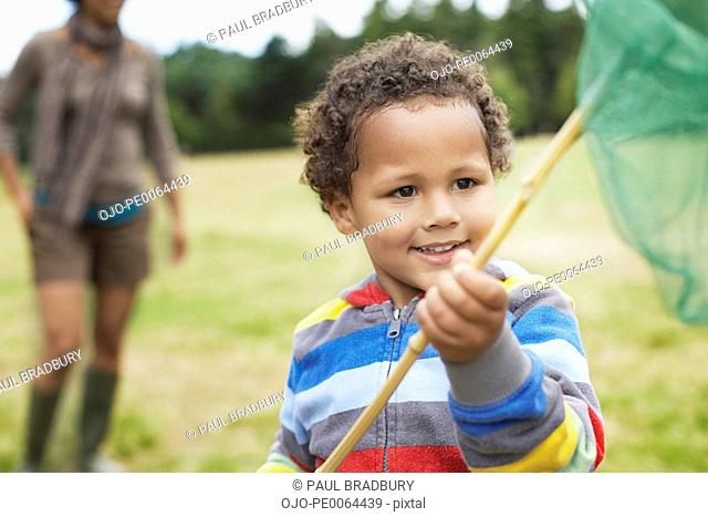 Boy playing in park with butterfly net