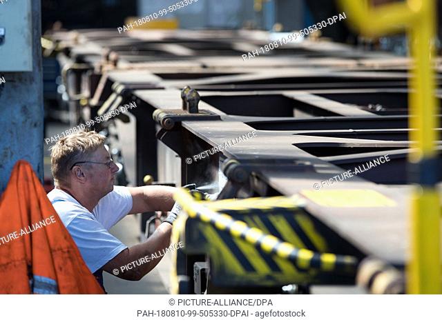 13 July 2018, Germany, Wittenberge: An employee in the workshop of DESAG subsidiary Schienenfahrzeugbau Wittenberge (SFW) sprays a new car number onto a...