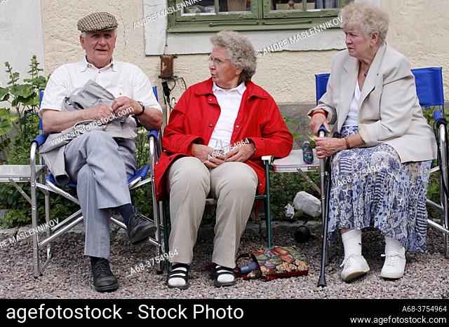 Pensioners are sitting on tent chairs