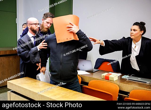 05 October 2023, Bavaria, Munich: The defendant (M) is led into a courtroom at the Munich II Regional Court at the start of the trial alongside his lawyers...