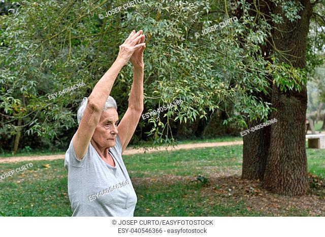 elderly woman practicing yoga outdoors
