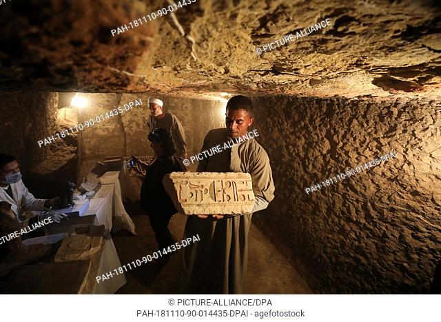10 November 2018, Egypt, Giza: A workers carries shows an artefact found inside the tomb of Khufu-Imhat, one of the newly discovered seven tombs belonging to...