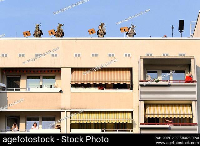 12 September 2020, Saxony, Dresden: Musicians of the Dresden Symphony Orchestra stand secured with belts on the roof of a high-rise building in the Dresden...