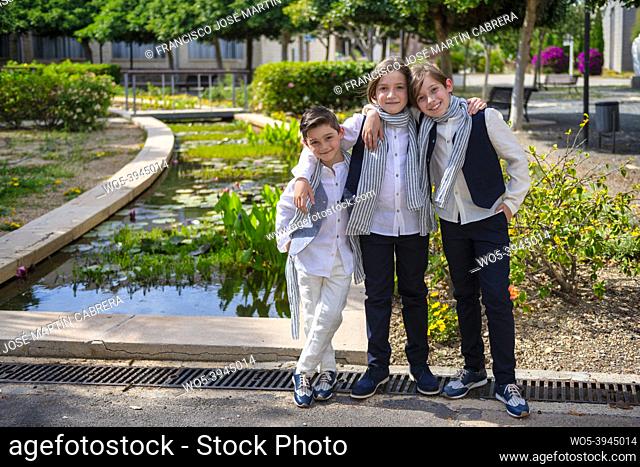 Three boys pose showing joy, casual and embraced, copy-space