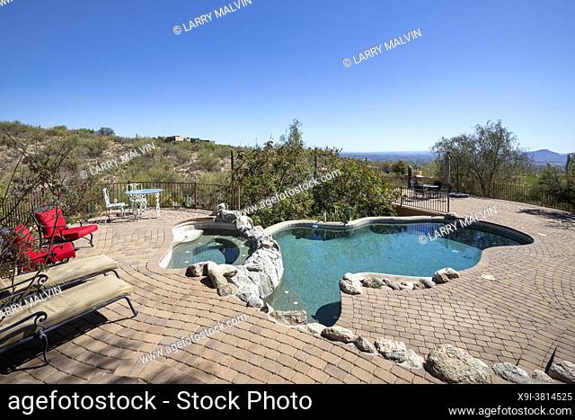 Swimming pool and hot tub on a terraced patio at a luxury home in a desert environment