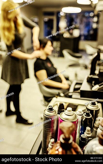 Cans of hairspray in a hairdressing salon, Hairdresser is doing the hair of a customer, North Rhine-Westphalia, Germany, Europe