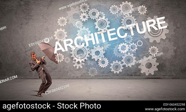 Businessman defending with umbrella from ARCHITECTURE inscription, technology concept