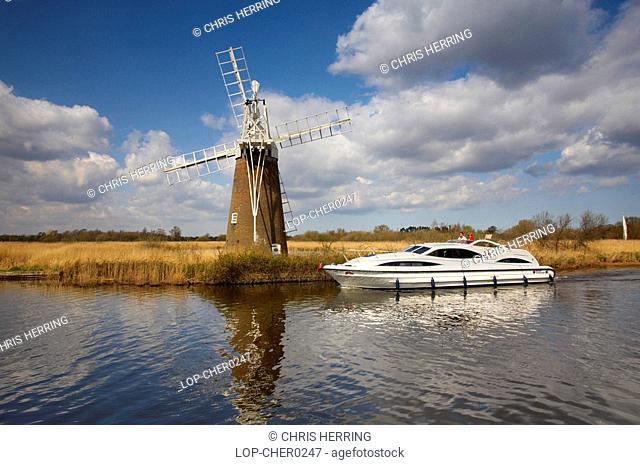England, Norfolk, Turf Fen, Turf Fen Windmill and a modern holiday motor cruiser sailing down the River Ant