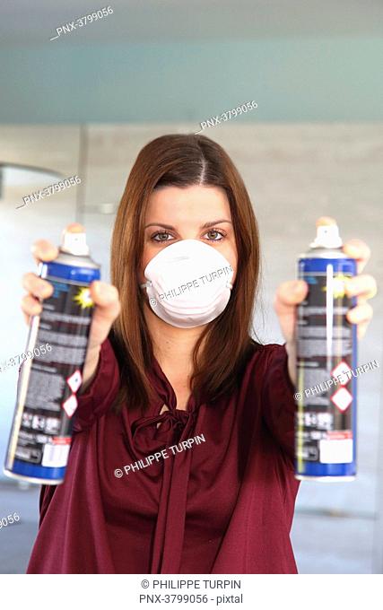 Young woman at home using air spray