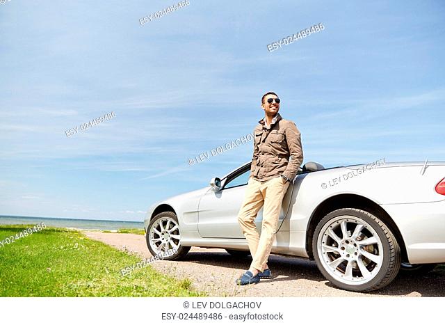 road trip, travel, transport, leisure and people concept - happy man near cabriolet car outdoors