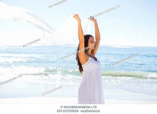 Happy brunette in white sun dress holding sarong