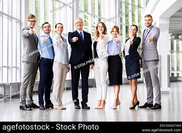 business people pointing to camera at office