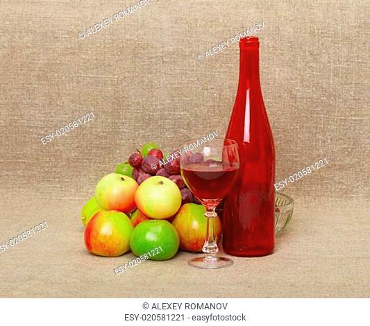 Still-life - bottle and fruit against a canvas