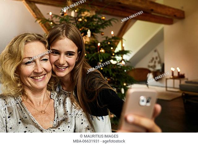 Mother and daughter in front of Christmas tree, Christmas Eve