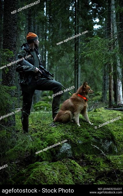 Hunter with dog in forest
