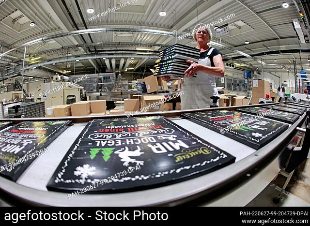 27 June 2023, Saxony-Anhalt, Wernigerode: Advent calendars roll off the production line at the Wergona Chocolate Factory