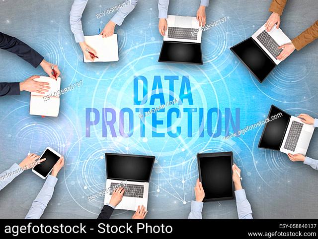 Group of people in front of a laptop with DATA PROTECTION insciption, web security concept