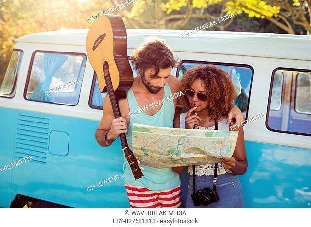 Couple looking at map near campervan