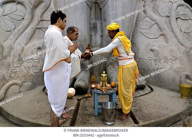 Pilgrims receive the blessings of Bahubali by a local priest on Indragiri hill in Sravanabelagola, Karnataka, India, Asia