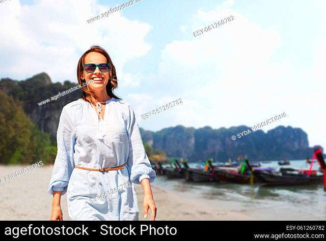 happy smiling woman walking along tropical beach
