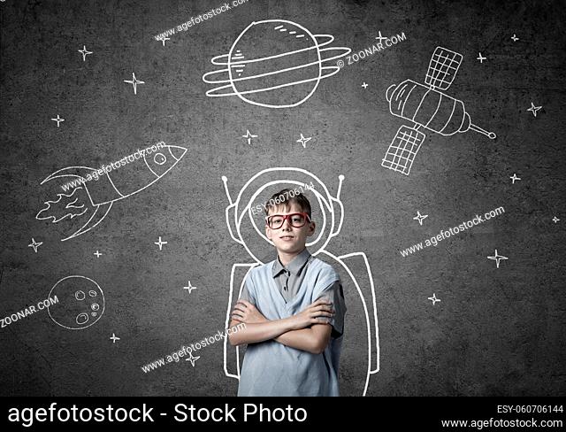 Cute boy of school age dreaming he is astronaut