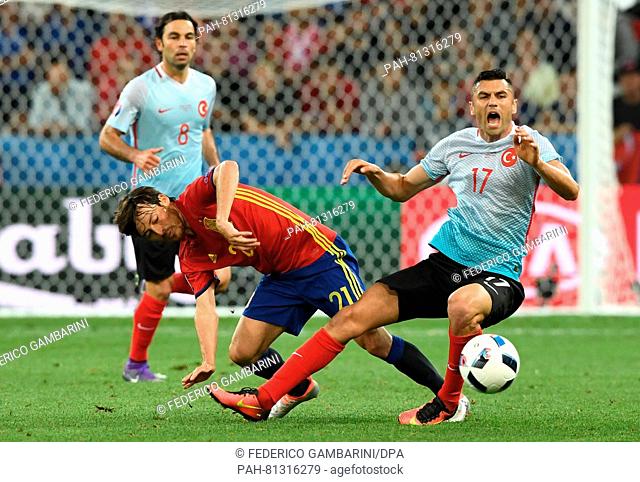 David Silva (L) of Spain vies for the ball with Burak Yilmaz of Turkey during the Group D soccer match of the UEFA EURO 2016 between Spain and Turkey at the...