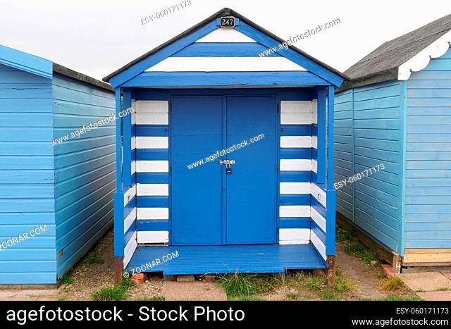 30 August 2021 - Essex, UK: Blue and white striped beach hut at seaside. High quality photo
