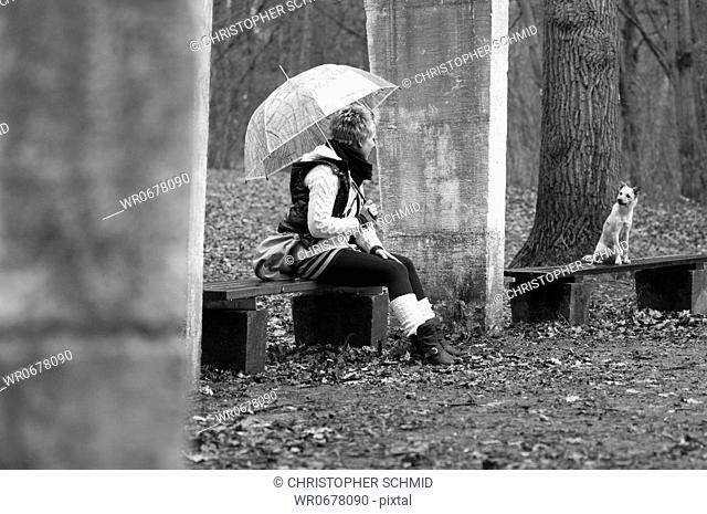 Young woman with umbrella and dog