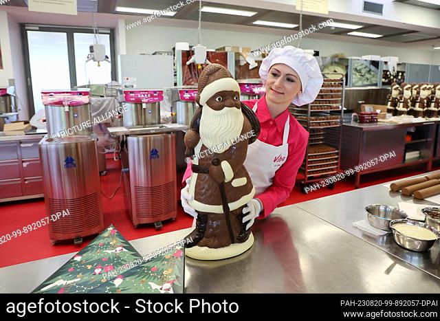 17 August 2023, Thuringia, Schmalkalden: Employee Josephiene Erbe holds a four-kilogram Santa Claus in her hand at Viba's production facility