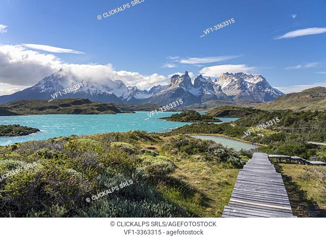 Boardwalk with Lake Pehoé and Paine Horns in the background, on a windy summer day. Torres del Paine National Park, Ultima Esperanza province, Magallanes region