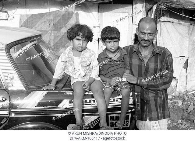 Taxi driver with children in malvani slum ; Malad ; Bombay Mumbai ; Maharashtra ; India NO MR