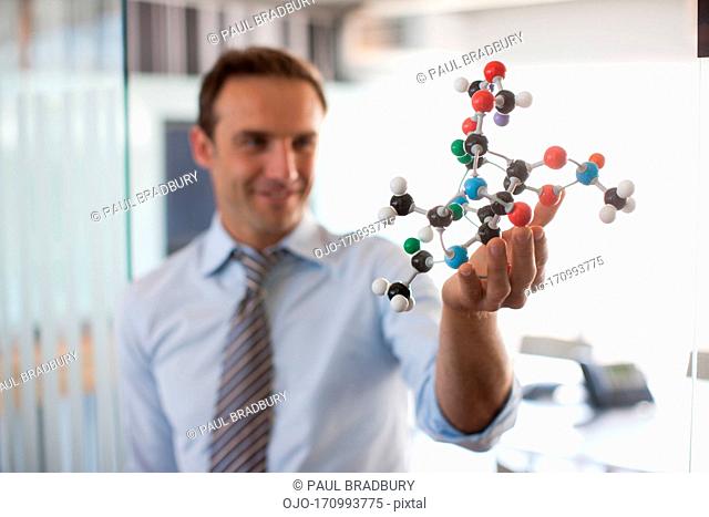 Businessman holding molecule model in office