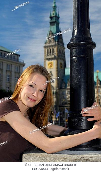 Young woman standing in front of the city hall in Hamburg, Germany