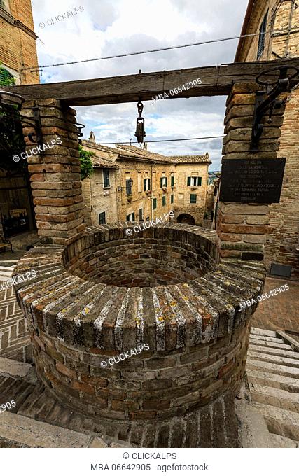 The ancient stone well among the houses of the old town of Corinaldo Province of Ancona Marche Italy Europe