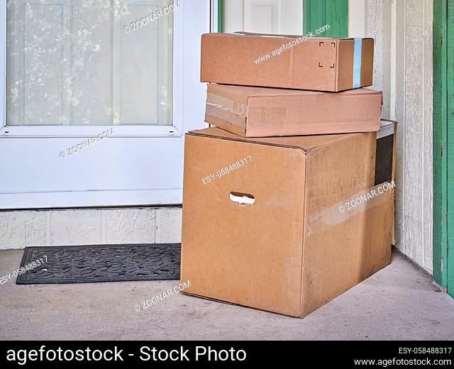 Contactless home delivery of product shopping - stack of cardboard boxes left at house door