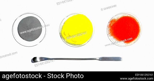 Zinc Powder, Potassium Chromate and Potassium Dichromate in chemical watch glass placed next to the stainless spatula. Closeup chemical ingredient on white...
