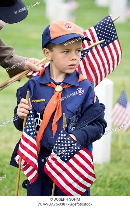 Cubscout places one of 85, 000 US Flags at 2014 Memorial Day Event, Los Angeles National Cemetery, California, USA