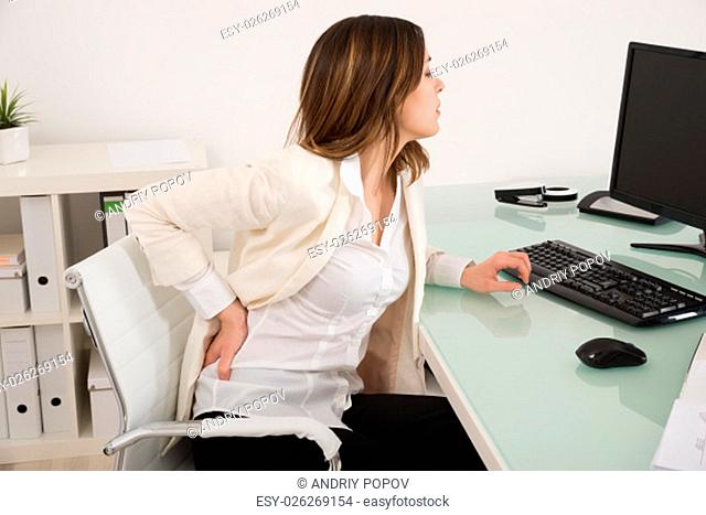 Young Businesswoman Suffering From Backache In Office