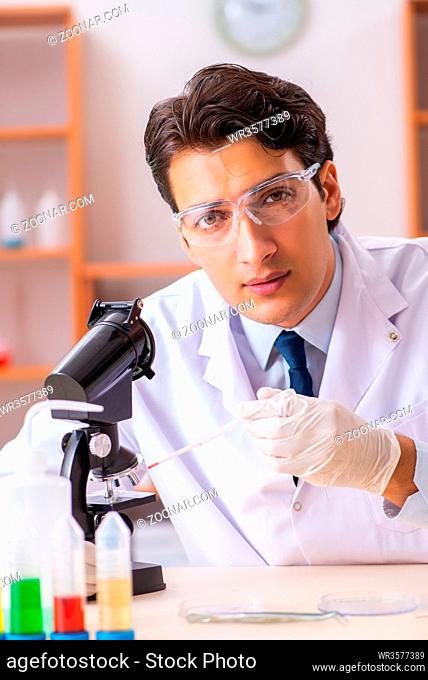 Young handsome biochemist working in the lab