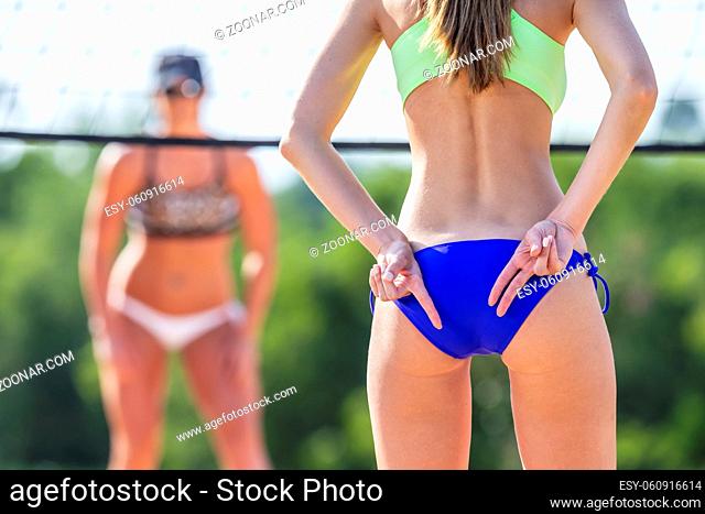 Two female athletes playing beach volleyball