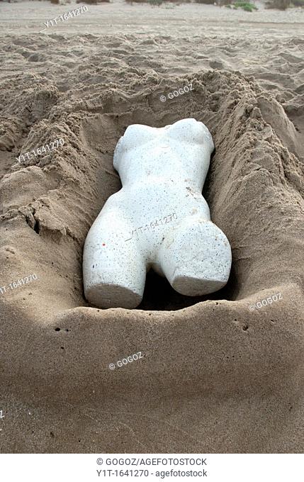 trunk of mannequin on sand in the beach