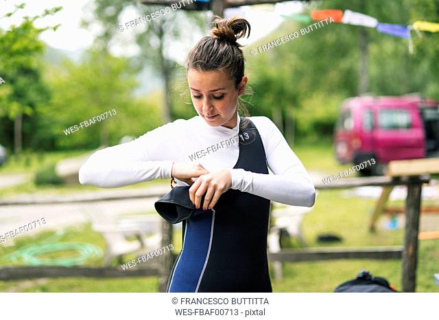 Woman preparing for a boat trip putting on wetsuit