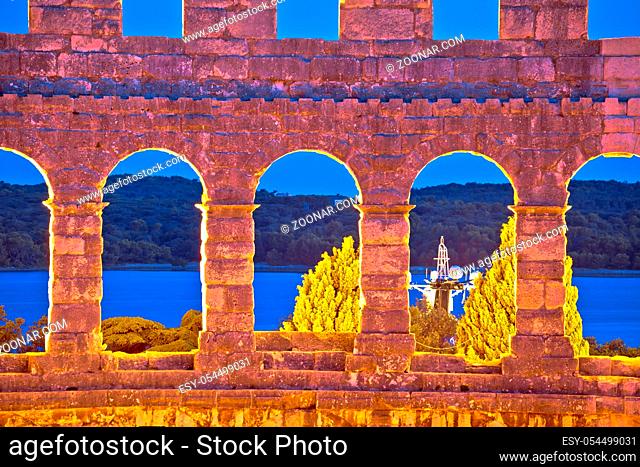 Evening view through walls and arches of Arena Pula, Roman amphitheater in Istria, Croatia