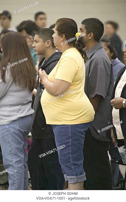 Profile of a Hispanic overweight woman amongst a group of other spectators in Oxnard, California