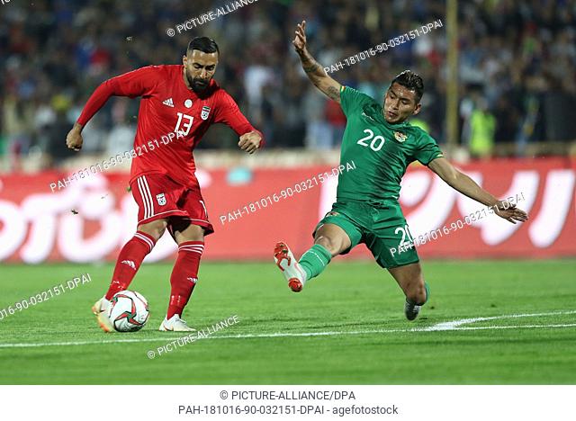 16 October 2018, Iran, Tehran: Iran's Saman Ghoddos and Bolivia's Rudy Cardozo battle for the ball during an International Friendly soccer match between Iran...