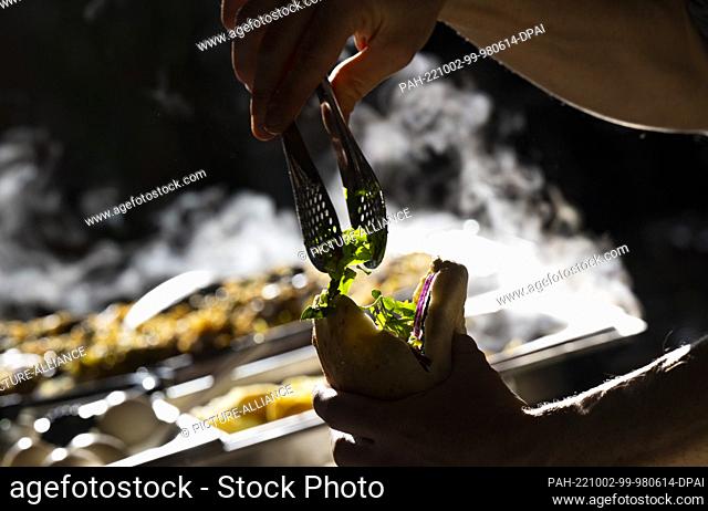 02 October 2022, Brandenburg, Potsdam: A man prepares Sabich in Pita, a traditional Jewish dish, at the Jewish Street Festival