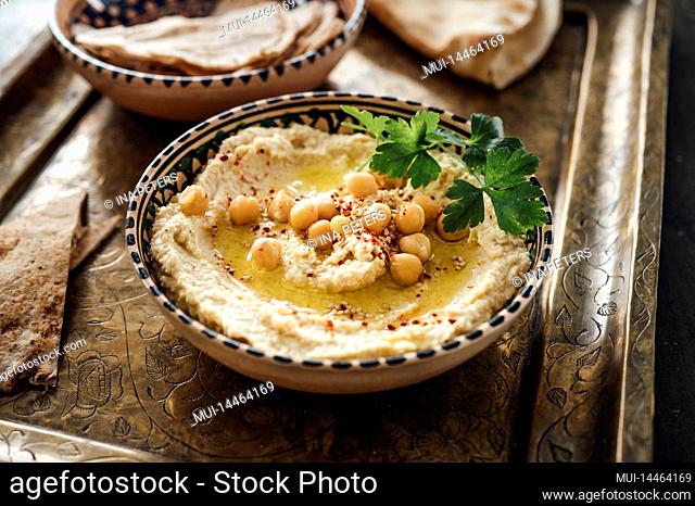 Homemade delicious chickpea hummus with olive oil, parsley