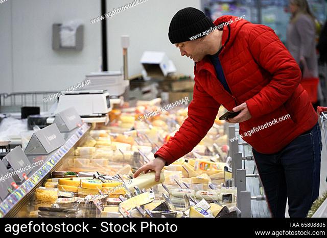 RUSSIA, NOVOSIBIRSK - DECEMBER 16, 2023: A customer chooses cheese in an Auchan hypermarket. Kirill Kukhmar/TASS